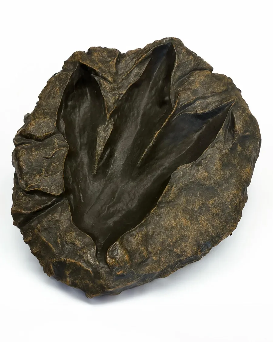 Handcrafted resin dinosaur footprint fossil replica, 10.5 x 9.3 inches, realistic shape with textured details in earthy tones.