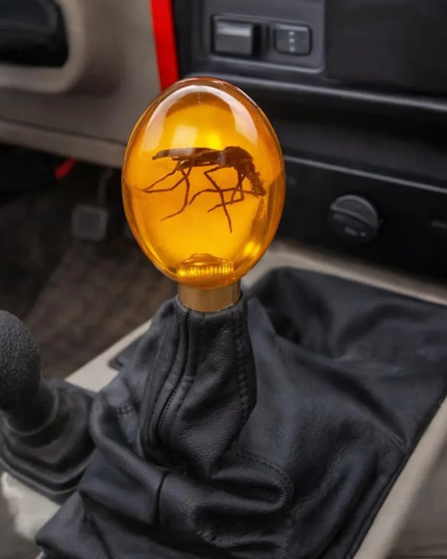 Mosquito suspended in amber-tone resin sphere, approximately 4 inches in diameter, with black base and mounting adapters included.
